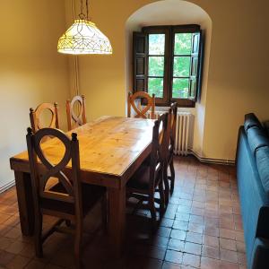 uma sala de jantar com uma mesa de madeira e cadeiras em Allotjament Sant Joan de Fabregues - Rupit i Pruit em Rupit