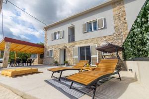 eine Terrasse mit Stühlen, einem Tisch und einem Gebäude in der Unterkunft Holiday Home Toni in Kaštel Stari