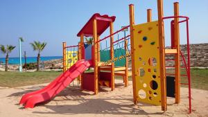 un parque infantil con un tobogán y un tobogán en Aktea Beach Village, en Ayia Napa