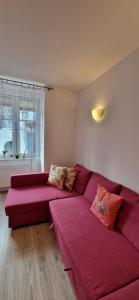 a living room with a red couch and a window at Sopot Baltic in Sopot