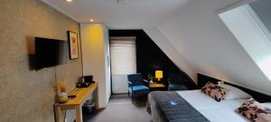 a bedroom with a bed and a desk and a chair at Pension Bakema Ameland in Nes