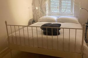 - un lit blanc avec un cadre en métal et des oreillers blancs dans l'établissement Luxurious 2 bedroom apartment with sea view in Monkstown, à Blackrock
