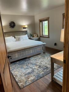 una camera con un grande letto e un tappeto di The Inn at Liberty Farms a Sunshine