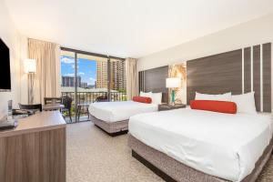 um quarto de hotel com duas camas e uma televisão de ecrã plano em Castle at Palms at Waikīkī em Honolulu