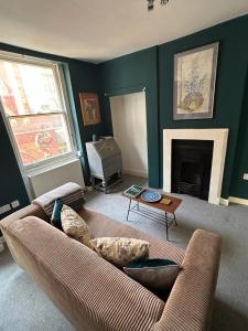John Street Apartment 3 في بريستول: غرفة معيشة مع أريكة ومدفأة