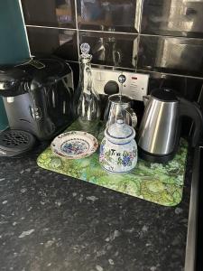 a counter top with a tea kettle and plates on it at John Street Apartment 3 in Bristol