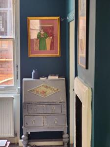 a blue room with a dresser and a painting on the wall at John Street Apartment 3 in Bristol