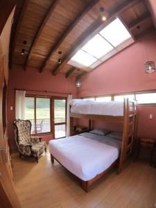 a bedroom with two bunk beds and a chair at Alojamiento Exclusivo en el Valle Sagrado in Cusco