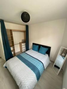 um quarto com uma cama com lençóis azuis e brancos em Appartement avec jardin privatif em Lorient