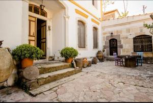 a courtyard of a building with potted plants on the steps at Saklı Konak in Karaburun