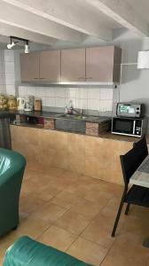 eine Küche mit einer Arbeitsplatte und einer Mikrowelle in der Unterkunft Ferienhaus Gare de Mareuil 