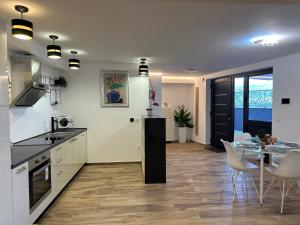 HILLSIDE Apartment Volosko في أوباتيا: مطبخ وغرفة طعام مع طاولة وكراسي