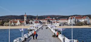 a pier with people walking on it on the water at Sopot Baltic in Sopot