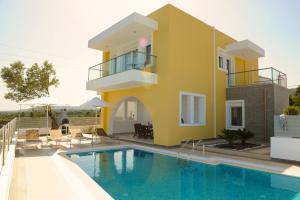 a villa with a swimming pool in front of a house at Gennadi Aegean Horizon Villas in Gennadi