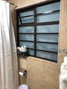 baño con cortina de ducha y ventana en Suites Incoreli 4, Centro Pachuca de Soto, en Pachuca de Soto