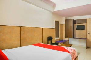 ein Hotelzimmer mit einem Bett und einem TV in der Unterkunft Flagship Sai Vishram in Bangalore