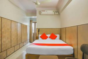 ein Schlafzimmer mit einem Bett mit roten Kissen darauf in der Unterkunft Flagship Sai Vishram in Bangalore