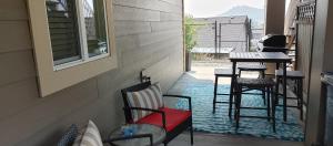 eine Veranda mit Stühlen und einem Tisch auf dem Balkon in der Unterkunft WineDownHere - Lic. 75806 in Kelowna