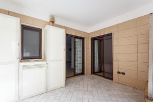 an empty room with wooden doors and windows at LA CONCHIGLIA SAMS HOME in Bisceglie