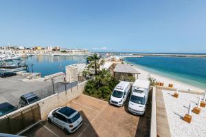 two cars parked in a parking lot next to a beach at LA CONCHIGLIA SAMS HOME in Bisceglie