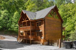 uma cabana de madeira com um alpendre e um deque em Mountain Cinema Lodge em Pigeon Forge