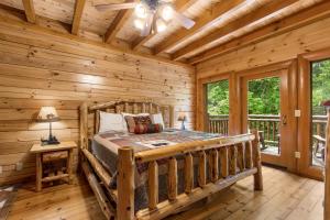 um quarto com uma cama num chalé de madeira em Mountain Cinema Lodge em Pigeon Forge