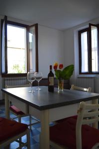 uma mesa com dois copos e uma garrafa de vinho em Casa degli Ulivi em Salò