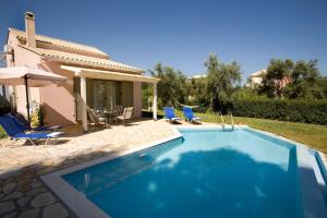a swimming pool in front of a house at Villa Fotini in Lefkada Town