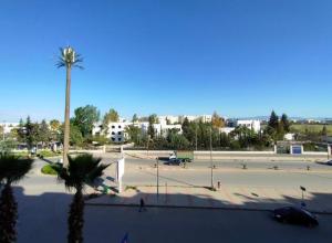 a large parking lot with a palm tree and a parking lot at Residence Ray in Fez