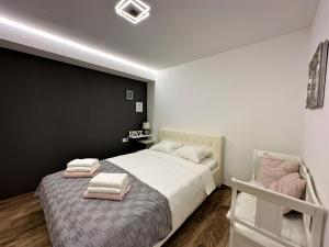HILLSIDE Apartment Volosko في أوباتيا: غرفة نوم بسرير كبير عليها مناشف