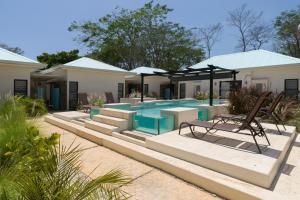 een villa met een zwembad en een huis bij Villas VR Beachwalk Avellanas in Playa Avellana