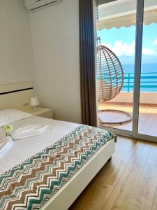 um quarto com uma cama e vista para o oceano em Aquamarine Apartments em Saranda