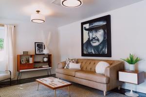 a living room with a couch and a painting on the wall at Villa Royale in Palm Springs