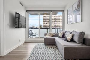 un salon avec un canapé et une grande fenêtre dans l'établissement Stylish Serenity 1BR Kensington Condo with Parking, à Calgary