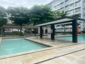 - une piscine avec un pavillon à côté d'un bâtiment dans l'établissement OK KADA Budget Inn MANILA QC, à Manille