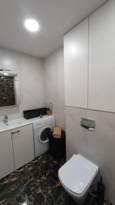a bathroom with a white toilet and a sink at Cozy apartment near Zalgiris Arena in Kaunas