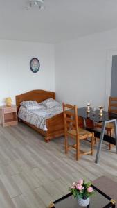 a bedroom with a bed and a table and a chair at Le lumineux sobre in Melun