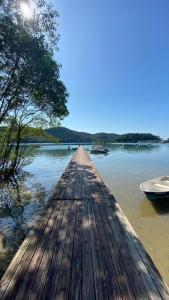 a wooden dock with a boat in the water at Club MV Saco do Céu in Abraão