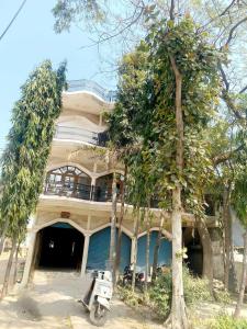 ein Haus mit einem Motorrad, das davor geparkt ist in der Unterkunft OYO Hotel Shubham Palace in Aligarh