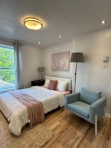 a bedroom with a bed and a blue chair at SAI GON Suit in Grimsby