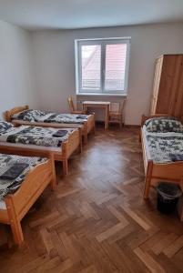 a room with four beds and a wooden floor at Ubytovanie Topoľčany in Topoľčany