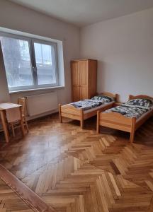 Habitación con 2 camas, mesa y ventana en Ubytovanie Topoľčany, en Topoľčany