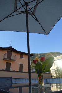 um vaso de flores sentado sob um guarda-chuva em Casa degli Ulivi em Salò