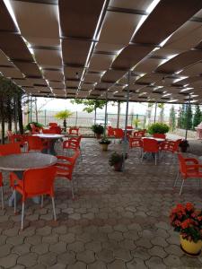 un patio con sillas, mesas y mesas rojas y una mesa en Beni Rooms Tale en Lezhë