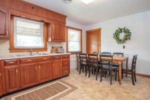 una cocina con armarios de madera y una mesa con sillas. en Pine Grove Cottage, en Chambersburg