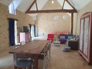 a living room with a table and a couch at Gîtes avec piscine chauffée in Rosnay