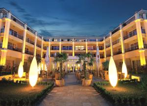 een hotel met een binnenplaats met palmbomen en verlichting bij Hotel Gran BelVeder & Ostsee Therme Resort & Spa in Scharbeutz