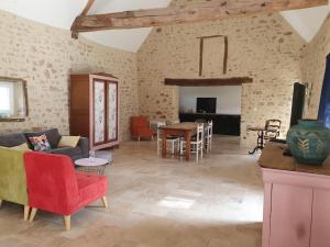a living room with a couch and a table at Gîtes avec piscine chauffée in Rosnay