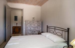 a bedroom with a white bed and a dresser at Nafsika House in Ayios Kirikos
