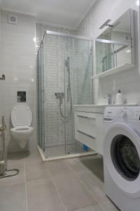 a bathroom with a shower and a washing machine at Apartman David in Trebinje